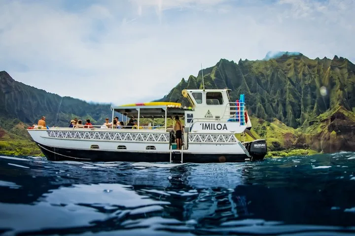 Open-sided catamaran 'Imiloa near the sea cliffs on a Na Pali Coast boat tour from Port Allen, Kauai