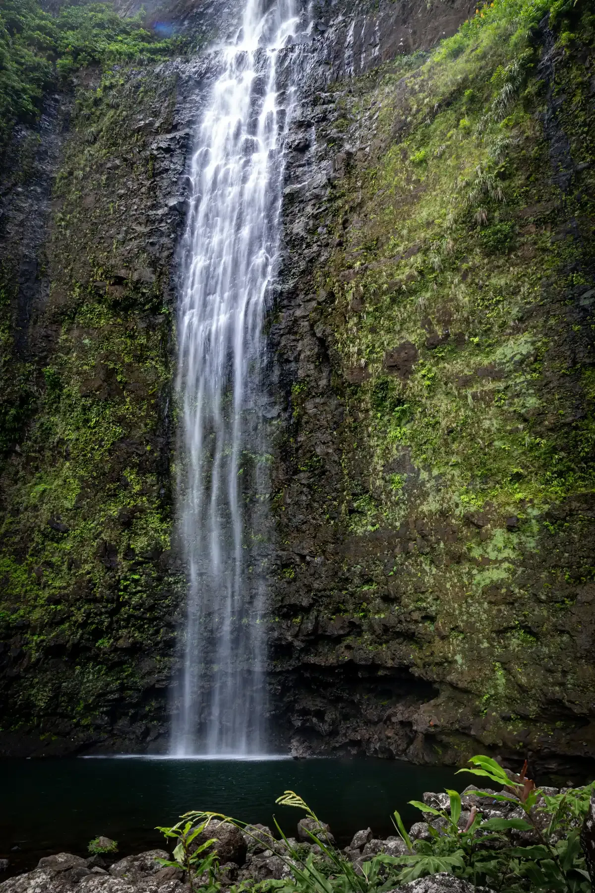 Hanakapiai Falls dropping down a green cliff on Kauai's Na Pali Coast