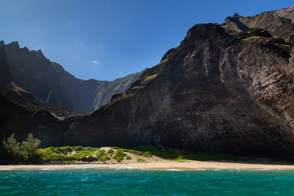 Honopu Beach and its tall cliffs on the Na Pali Coast, a highlight of Kauai Napali Coast boat tours