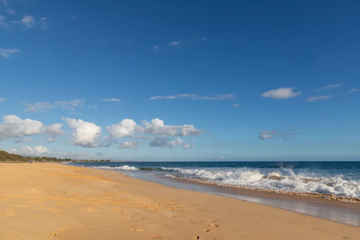 Waves rolling onto Kekaha Beach on west Kauai near Kikiaola Harbor for Napali Coast boat tours