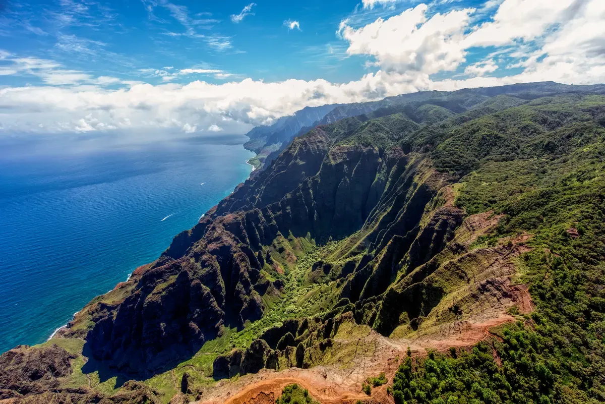 Aerial view of the folded Na Pali Coast ridges and open ocean for Kauai Napali Coast boat tours