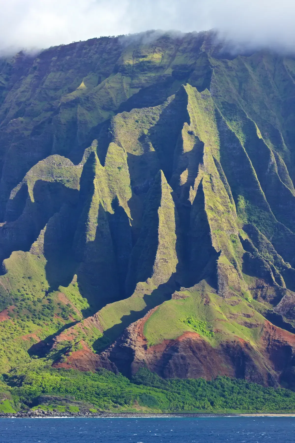 Sharp green Na Pali Coast ridges rising from the sea, seen on Kauai Napali Coast raft tours