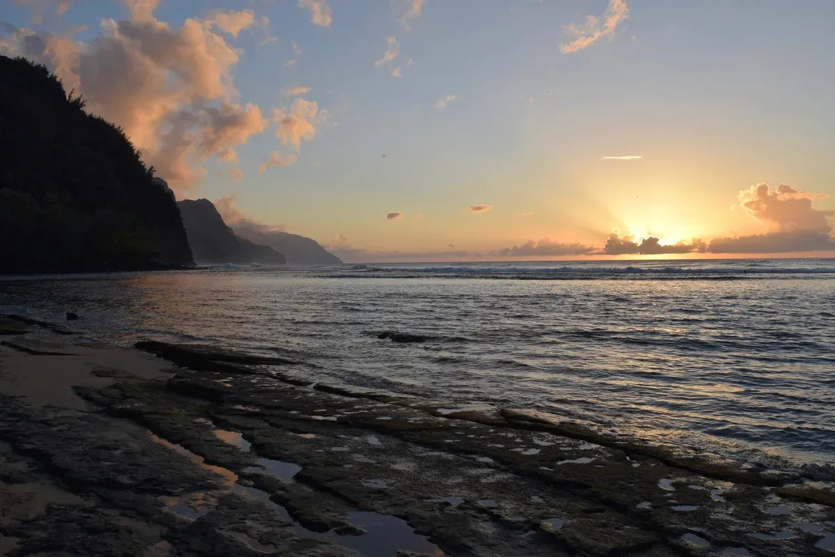 Sunset at Kee Beach with the Na Pali Coast cliffs on Kauai, the view on Napali Coast sunset sails